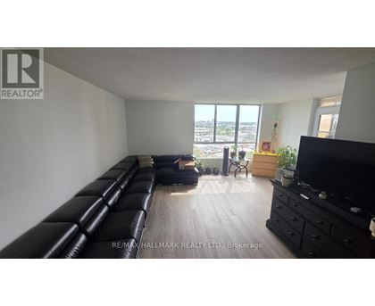 A living room with a long black couch and a flat screen TV.