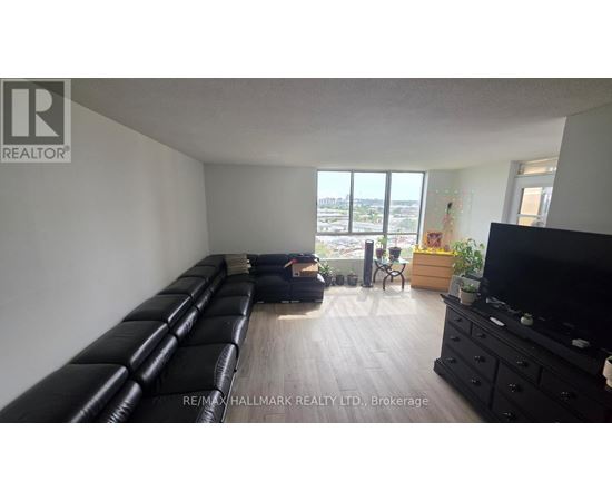 A living room with a long black couch and a flat screen TV.