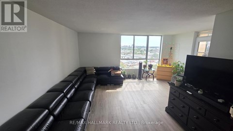 A living room with a long black couch and a flat screen TV.