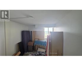 A bedroom with a bed, chair, and a window.
