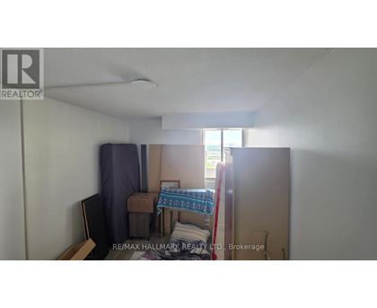A bedroom with a bed, chair, and a window.