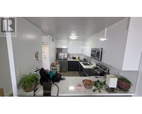 A kitchen with white cabinets and a black countertop.