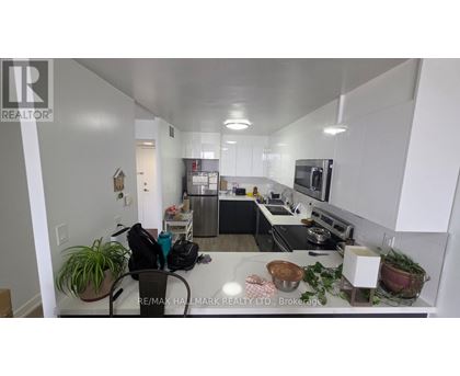 A kitchen with white cabinets and a black countertop.