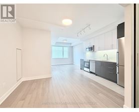 A spacious kitchen with stainless steel appliances and white cabinets.
