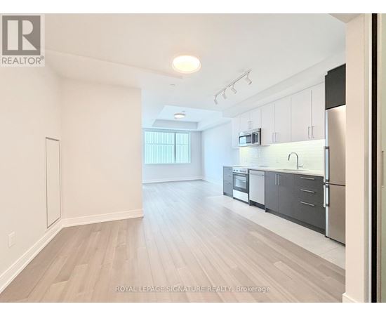A spacious kitchen with stainless steel appliances and white cabinets.