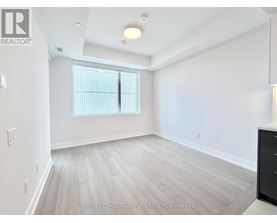 A spacious room with a window and wooden flooring.