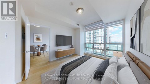 A bedroom with a large bed and a balcony overlooking a city.