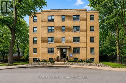 A tall brick building with a blue sign in front that says RE/MAX EXCEL TITAN Brokerage.