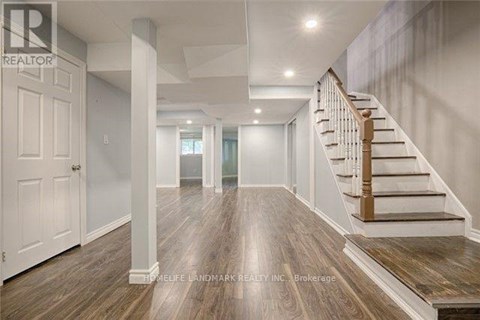 A spacious hallway with wooden floors and a staircase.
