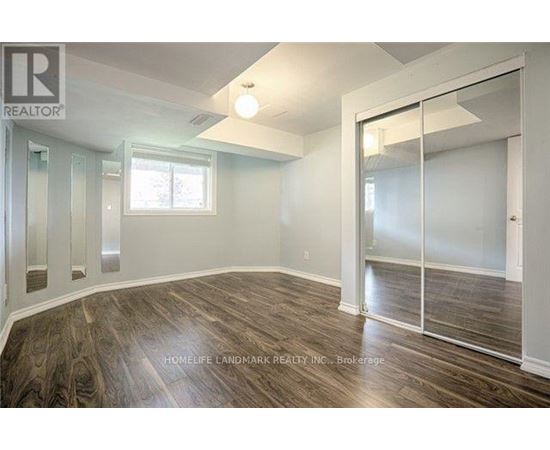 A room with wood flooring and a sliding glass door.