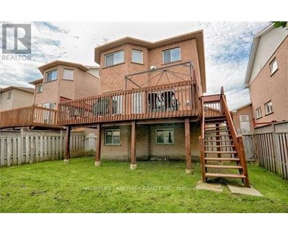 A large house with a deck and a staircase leading to it.
