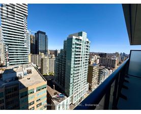 A cityscape with a clear blue sky and buildings of various heights.