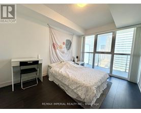A bedroom with a bed, desk, and chair.