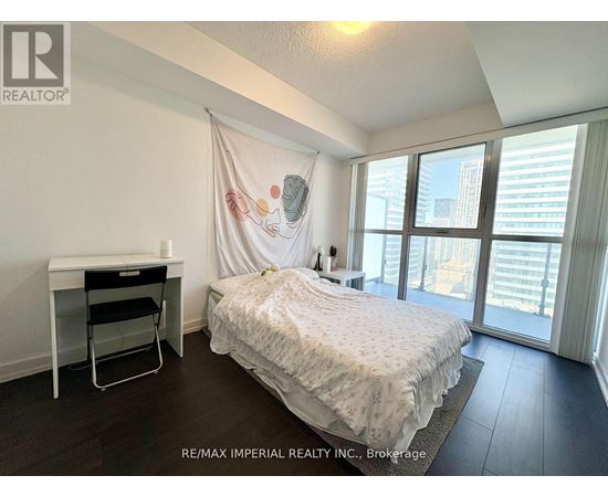 A bedroom with a bed, desk, and chair.