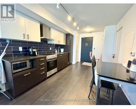 A kitchen with dark wood floors and a black counter top.
