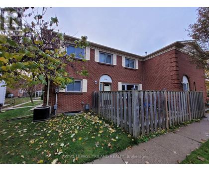 A brick house with a fence in front of it.