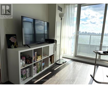 A living room with a television and a large window.
