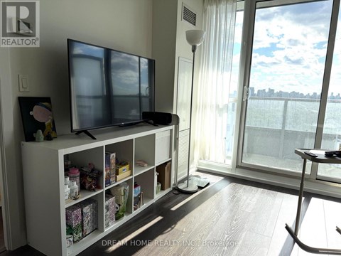 A living room with a television and a large window.