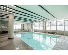 A large indoor swimming pool with a glass bottom.