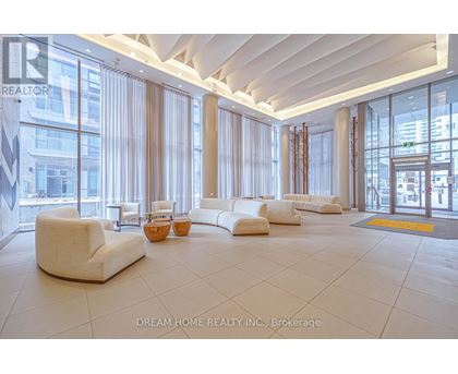 A spacious waiting area with white furniture and large windows.