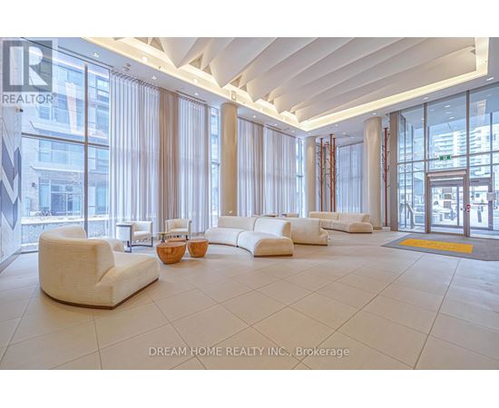 A spacious waiting area with white furniture and large windows.