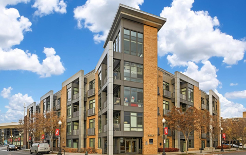 A modern multi-story building with a mix of brick and panel construction.