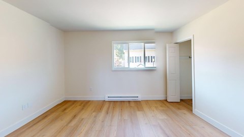 A room with wooden flooring and a window.