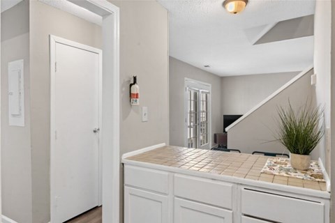 A kitchen with white cabinets and a tiled countertop.
