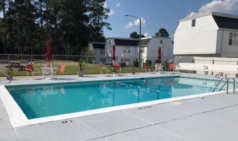 A large swimming pool with a white building in the background.