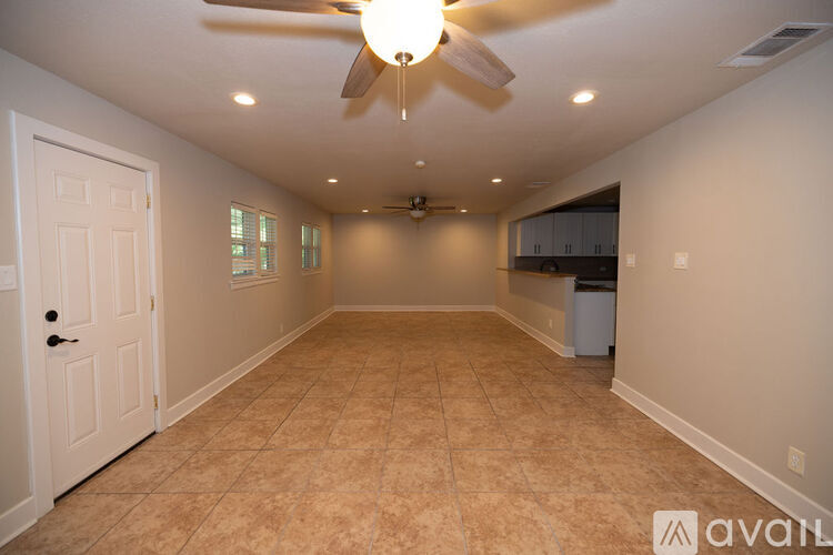 A spacious room with a ceiling fan and tiled floor.