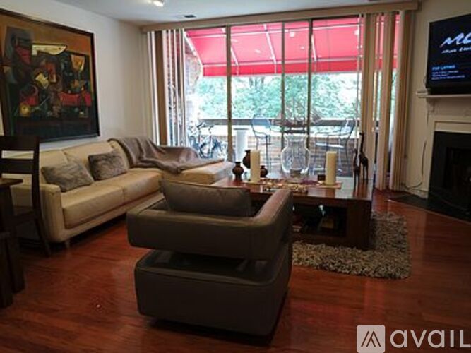 A living room with a couch, chair, and television.