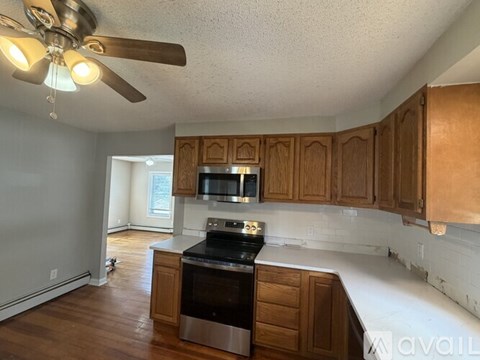 A kitchen with wooden cabinets and a black refrigerator.