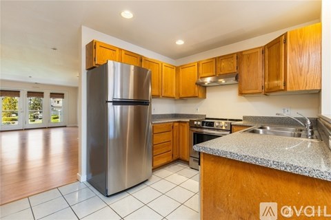 A kitchen with wooden cabinets and a stainless steel refrigerator.
