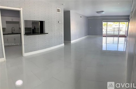A spacious room with a brick wall and a flat screen TV mounted above a fireplace.