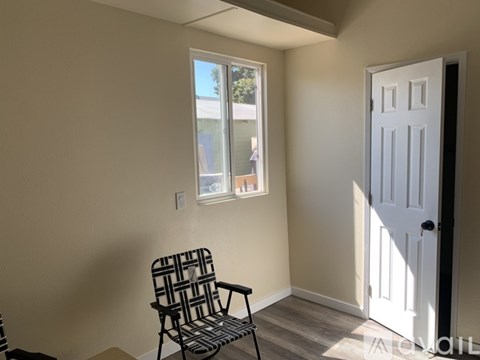 A chair is in a room with a door and a window.