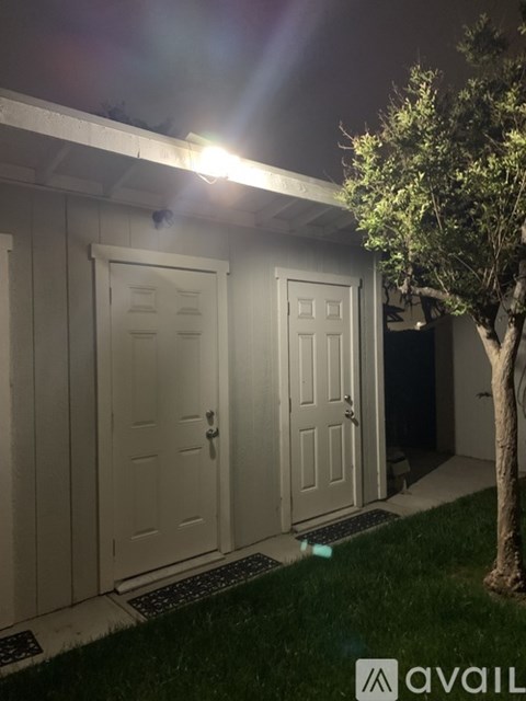 A white garage door is illuminated by a bright light.