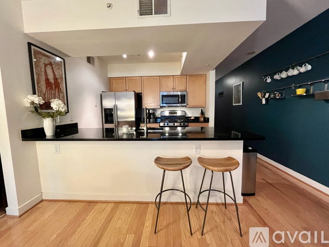 A kitchen with a white counter and bar stools.