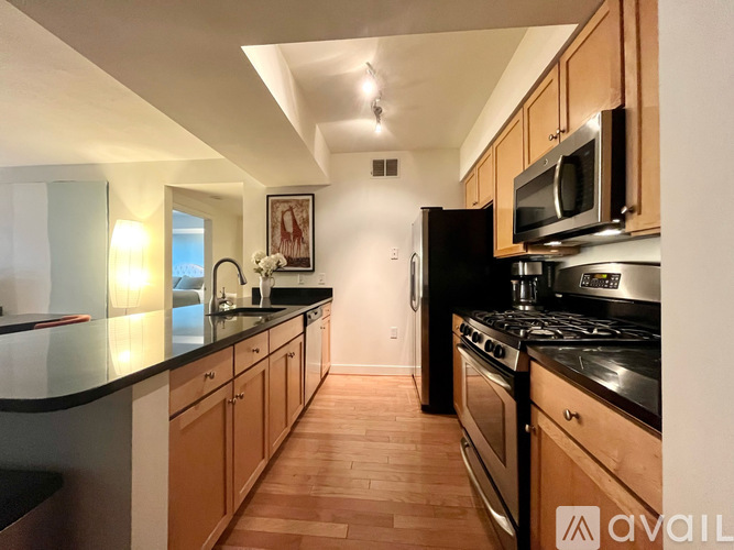 A kitchen with wooden cabinets and black countertops.
