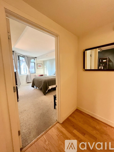 A bedroom with a bed and a mirror on the wall.