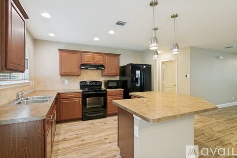 A kitchen with wooden cabinets and a black refrigerator.