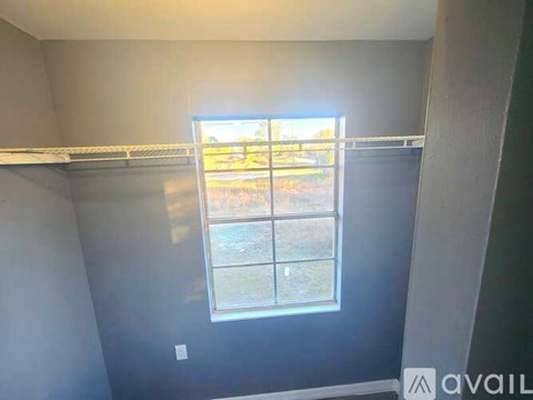 A room with a window showing a view of a grassy area.