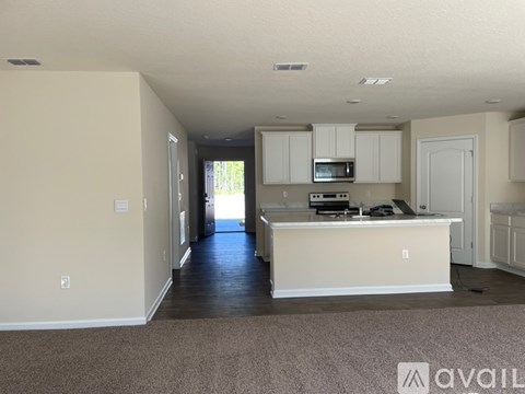 A kitchen with white cabinets and a countertop is available for rent.