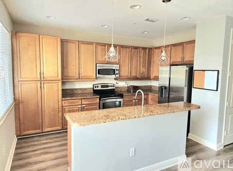 A kitchen with wooden cabinets and granite countertops.