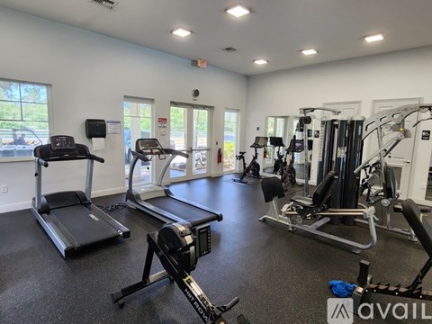 A gym with treadmills, elliptical machines, and other exercise equipment.