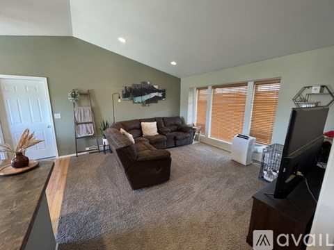 A living room with a brown couch and a television.