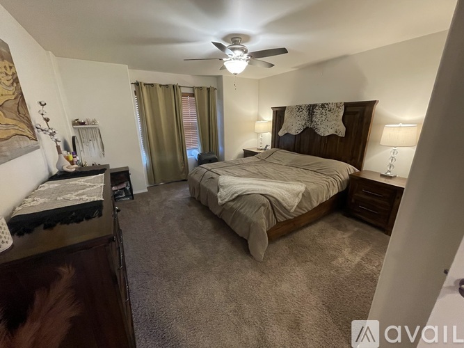 A bedroom with a large bed and a ceiling fan.