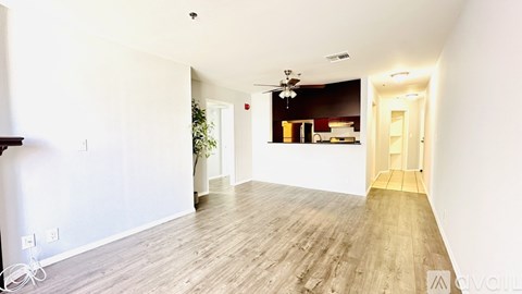 A spacious room with wooden flooring and a ceiling fan.