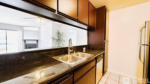 A kitchen with brown cabinets and a black counter top.