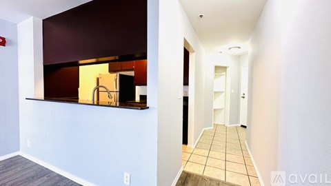 A hallway with a tiled floor and white walls.