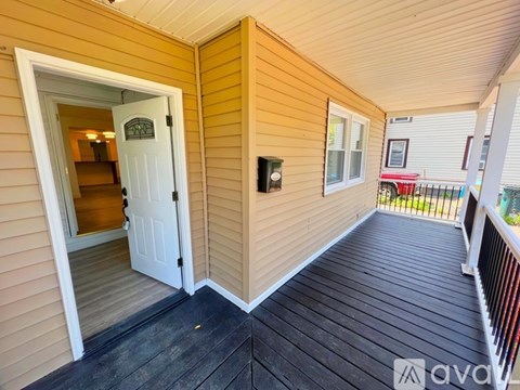 A balcony with a railing and a doorway leading to another room.